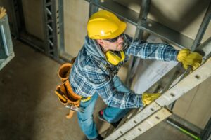 Worker climbing ladder in construction site
