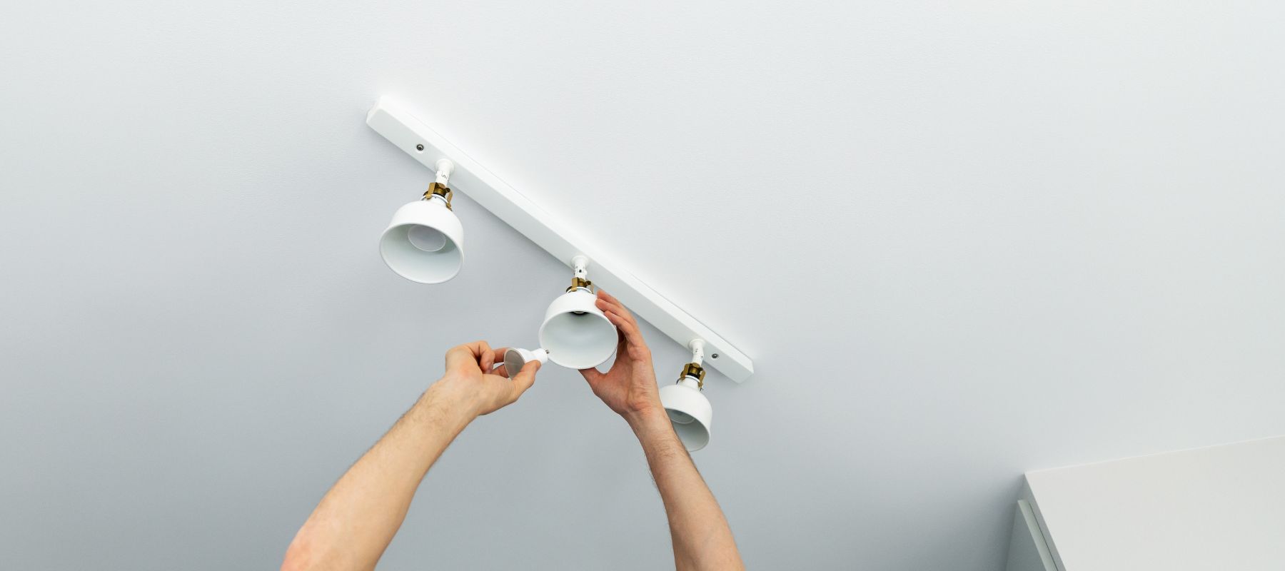 Person installing ceiling light fixture